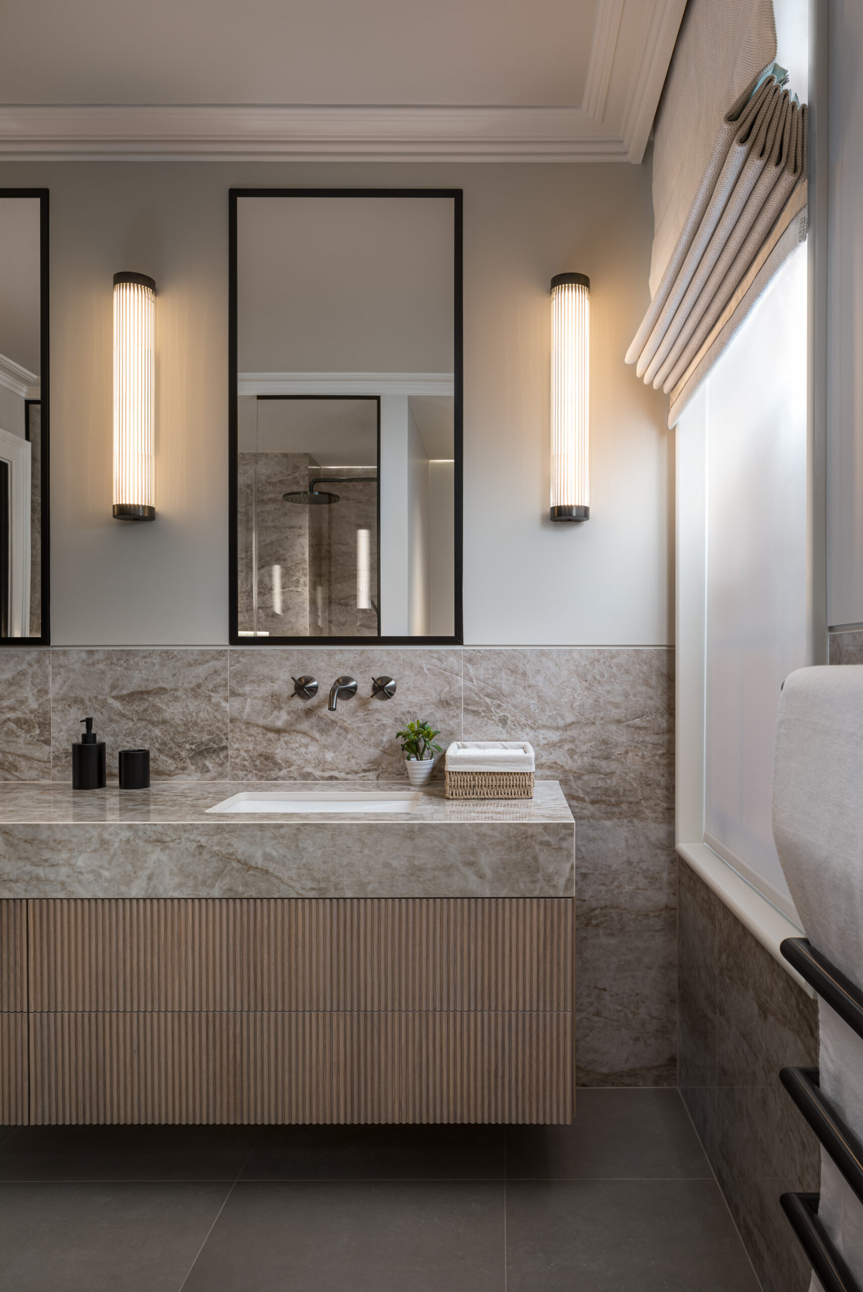 Light Bathroom with marble sink, mirrors and unique lights